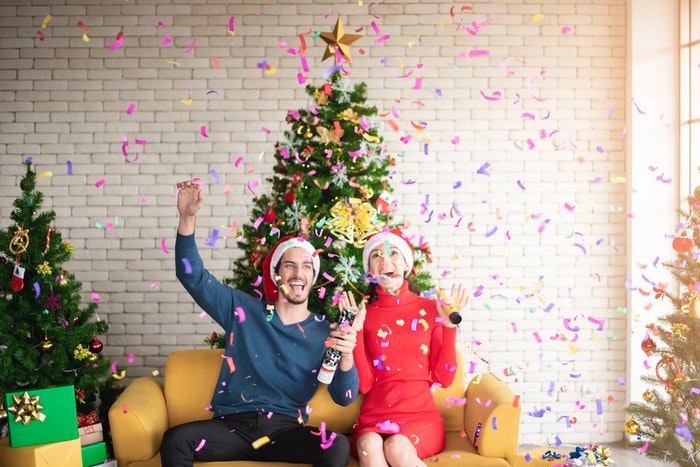 man and woman celebrating Christmas with a bottle 