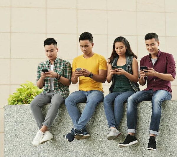 group young asian people sitting street using smartphones