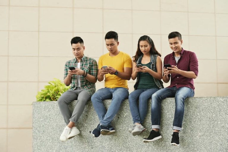 group young asian people sitting street using smartphones