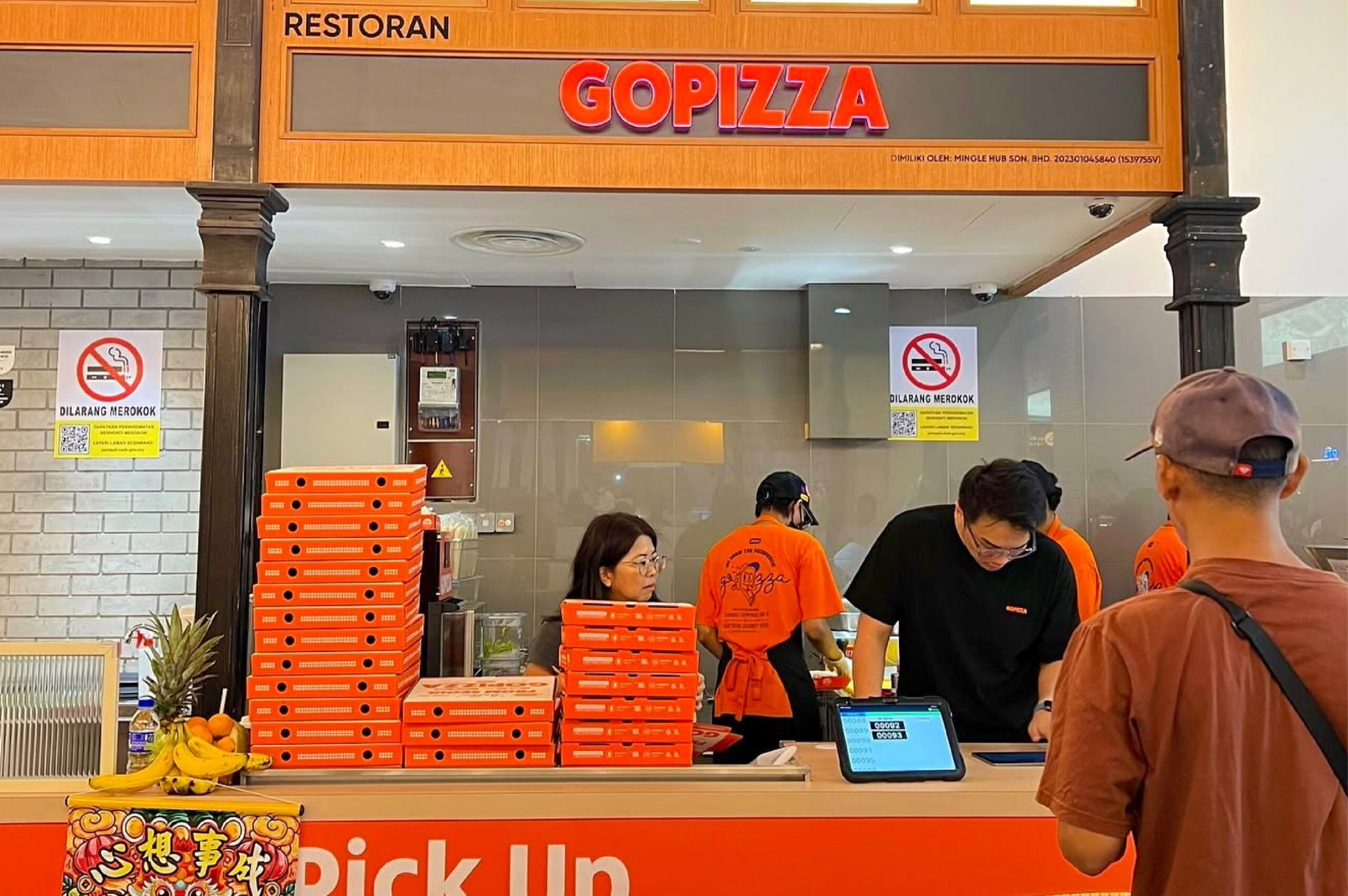 GOPIZZA staff enrolling a customer at the checkout counter